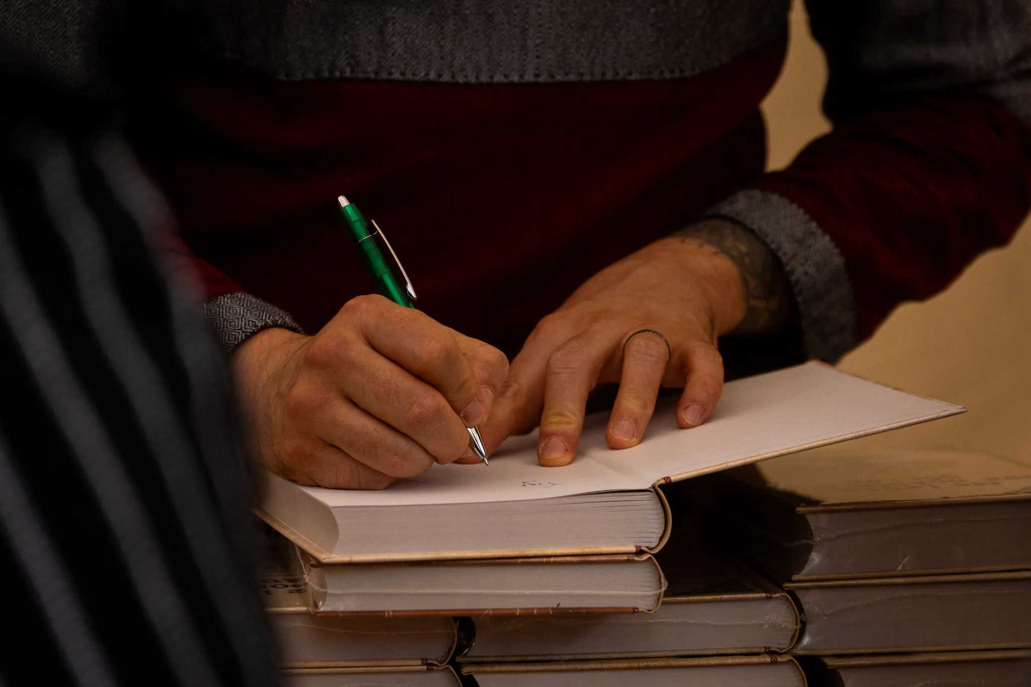 Autor Alexander Ellmer signiert ein Buch am NorseStory-Marktstand